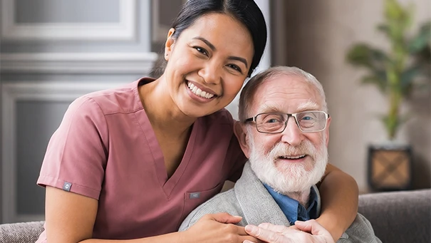 Caregiver hugging elderly man showing affection and care relationship.