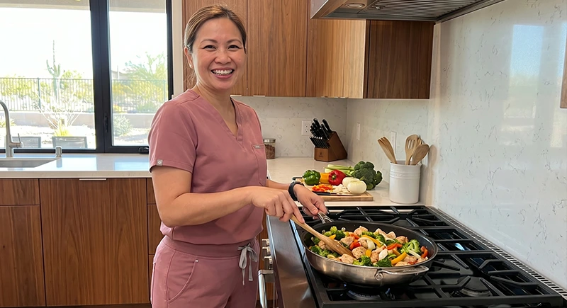 Caregiver is in the kitchen cooking a hot meal for a patient, providing homemaker support.